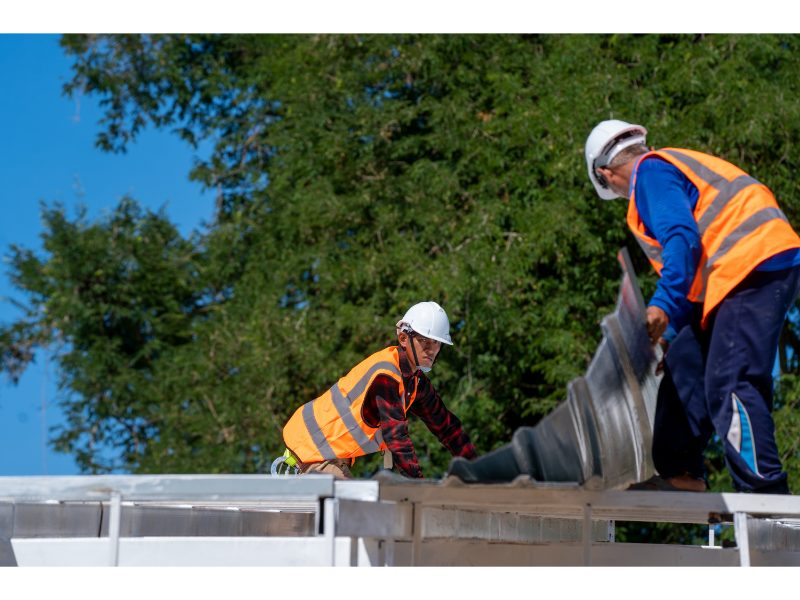 Roofing technicians installing a weather-resistant roof layer