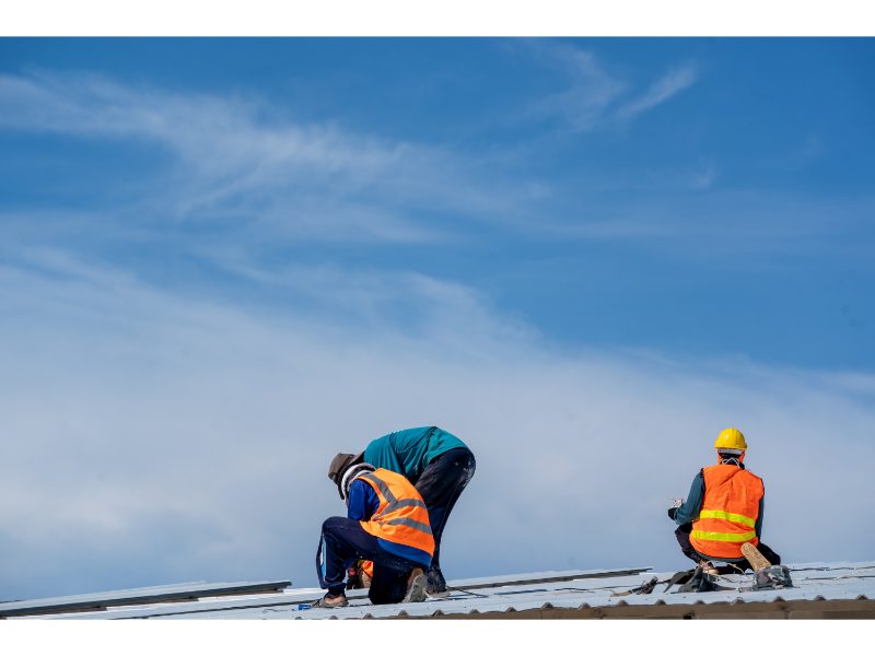 Roofers checking a metal roof installation